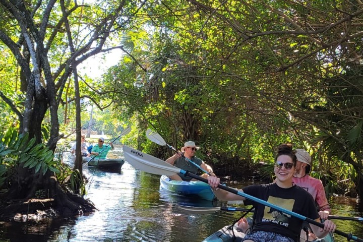 a group of people riding on the back of a boat in the water